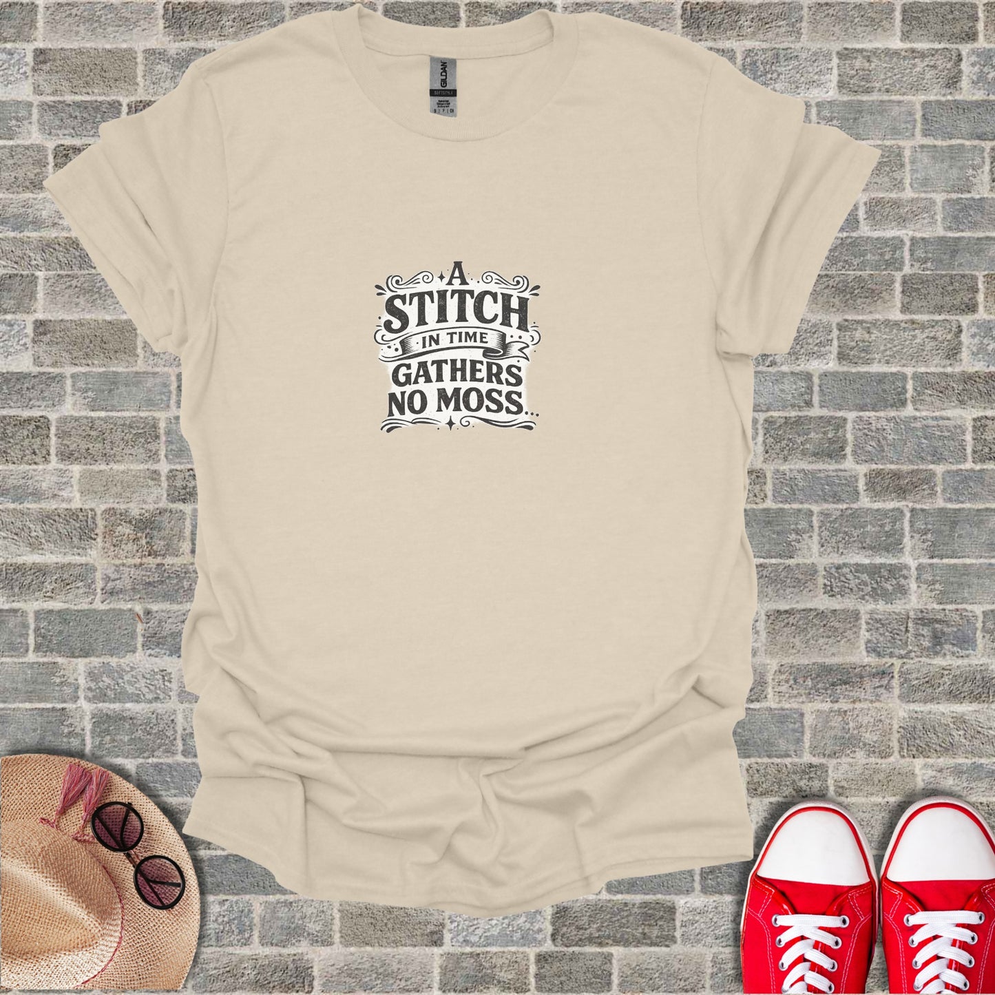 Cream t-shirt with "A stitch in time gathers no moss" text.