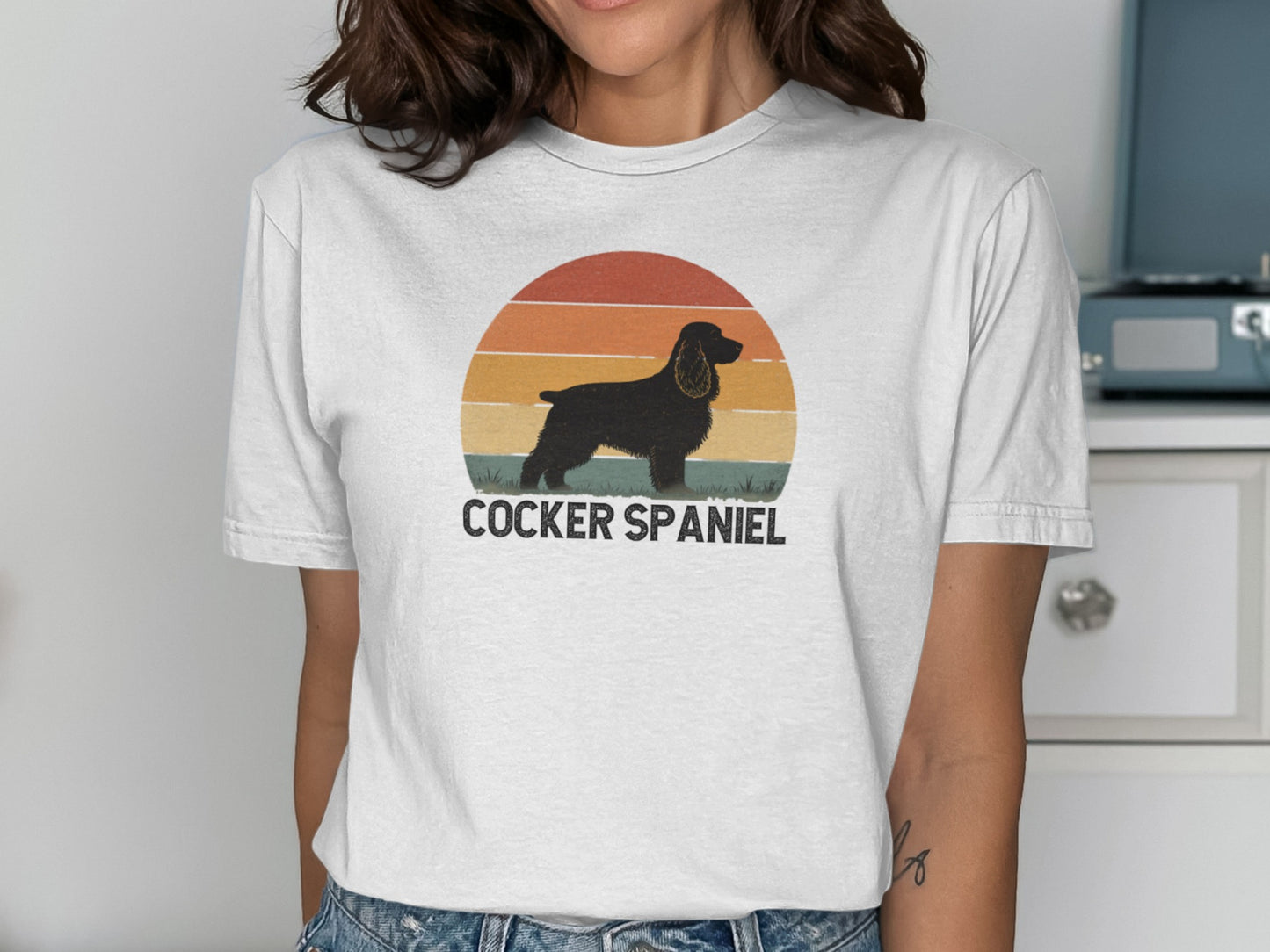 Black cocker spaniel silhouette against a sunset on a white t-shirt.