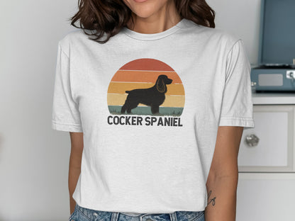 Black cocker spaniel silhouette against a sunset on a white t-shirt.