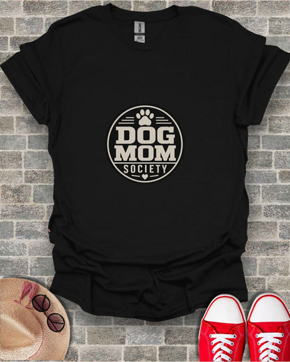 Black t-shirt with "Dog Mom Society" circular logo, red sneakers, and straw hat.