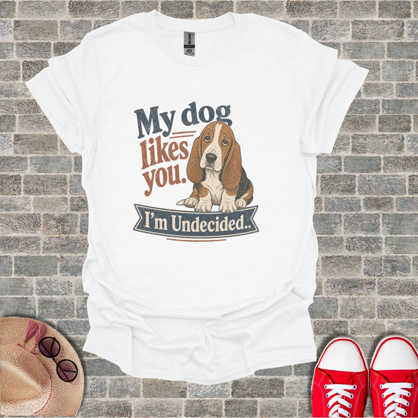 White t-shirt with graphic of basset hound and text "My dog likes you. I'm Undecided."