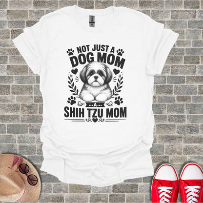 White t-shirt with black graphic of a Shih Tzu and text "Not just a dog mom... a shih tzu mom".