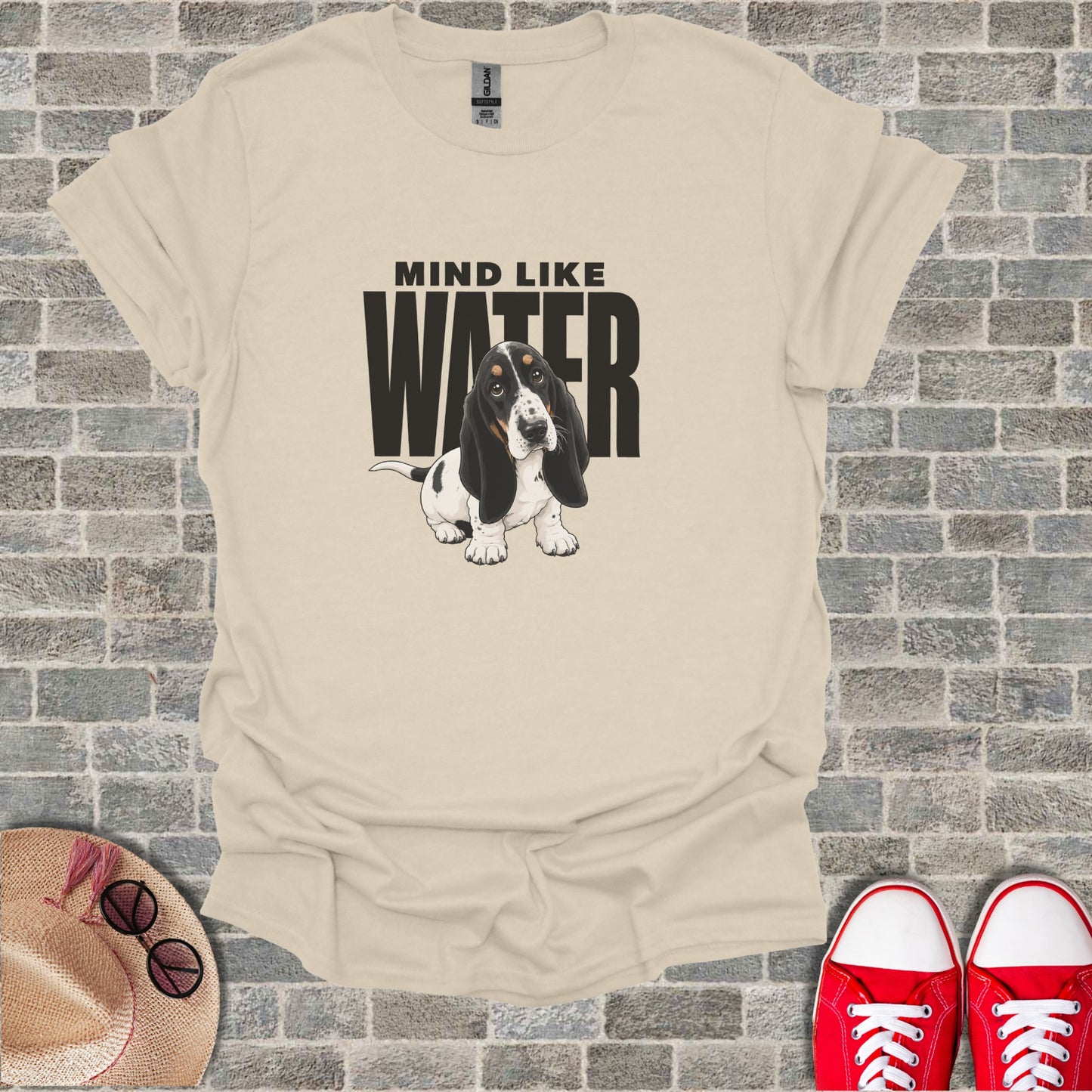 Basset hound wearing a t-shirt with "MIND LIKE WATER" text.
