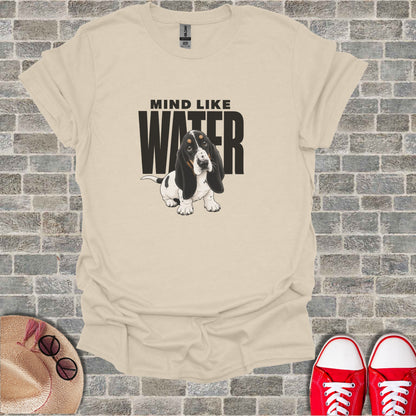 Basset hound wearing a t-shirt with "MIND LIKE WATER" text.