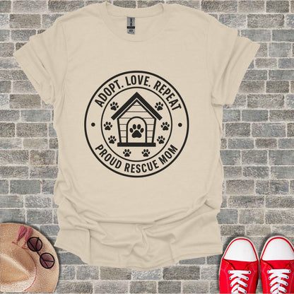 Cream t-shirt with black graphic: "Adopt. Love. Repeat. Proud Rescue Mom."