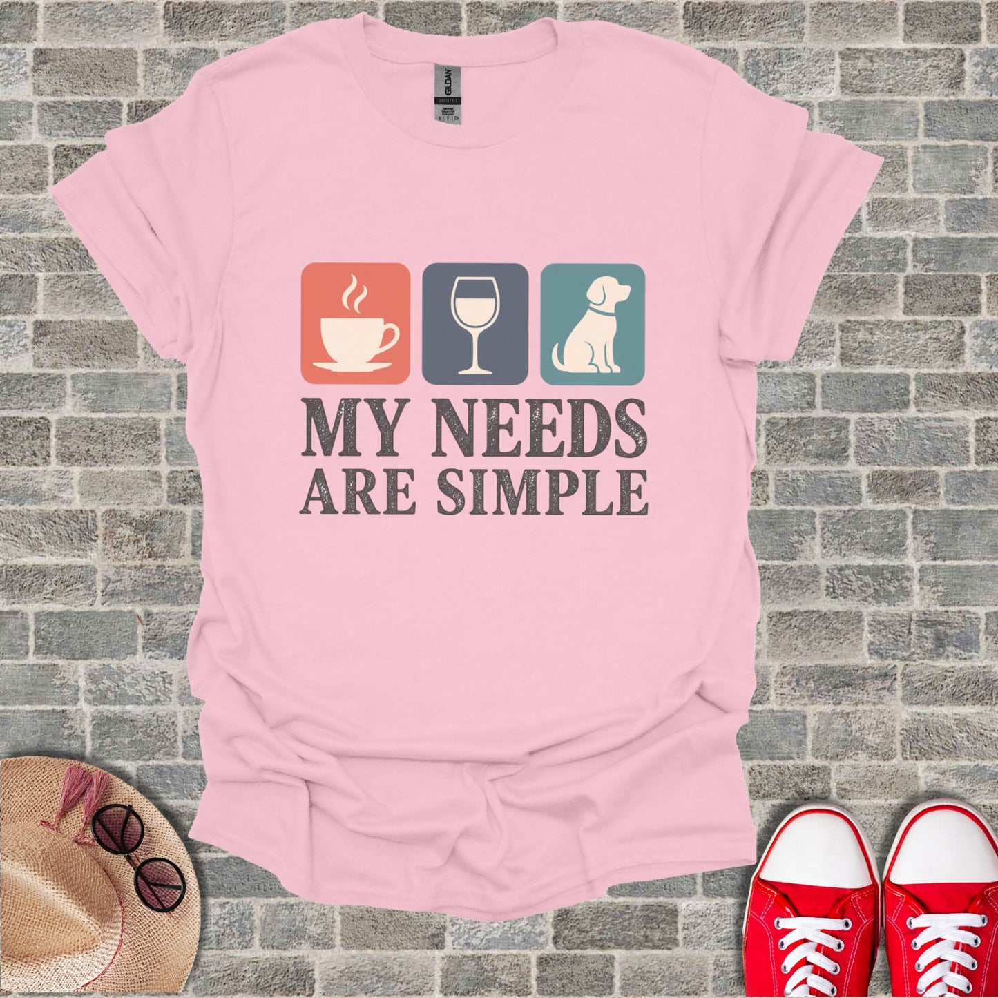 Pink t-shirt with graphic: coffee, wine, dog icons and text "MY NEEDS ARE SIMPLE".