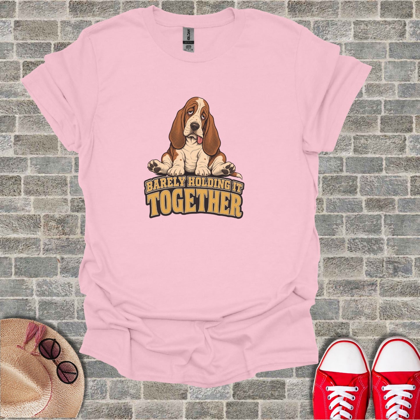 Pink t-shirt with cartoon Basset Hound and text "Barely Holding It Together."