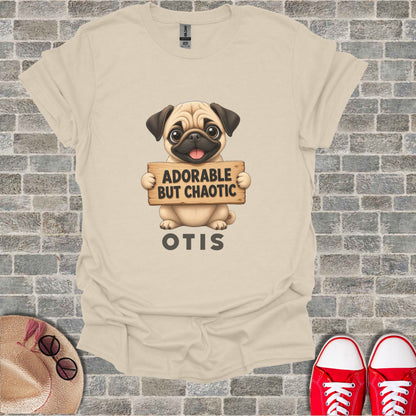 Cream t-shirt with a pug graphic holding a sign that says "Adorable But Chaotic Otis".
