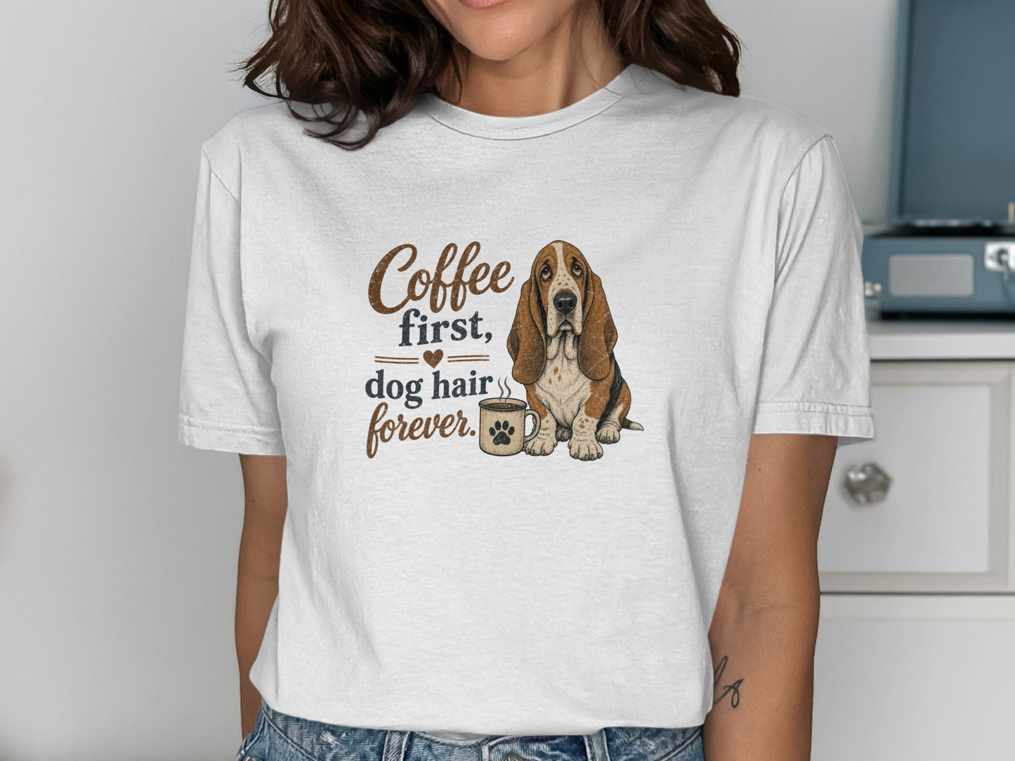Basset hound next to a coffee mug with text "Coffee first, dog hair forever."