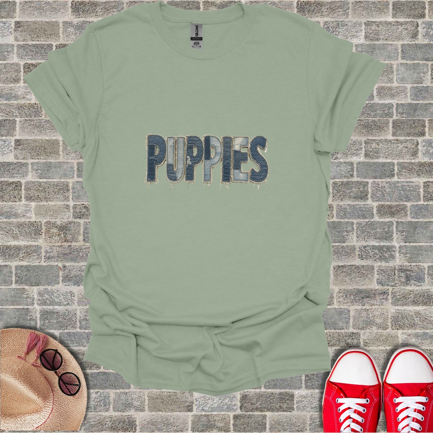 T-shirt with "PUPPIES" text in denim font on light green fabric.