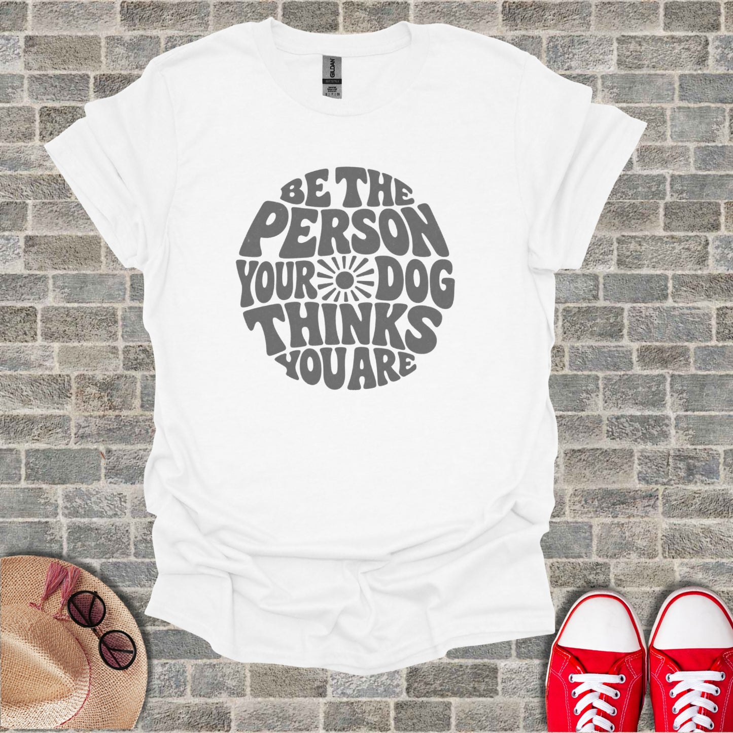 White t-shirt with gray text that reads: "BE THE PERSON YOUR DOG THINKS YOU ARE".