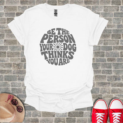 White t-shirt with gray text that reads: "BE THE PERSON YOUR DOG THINKS YOU ARE".