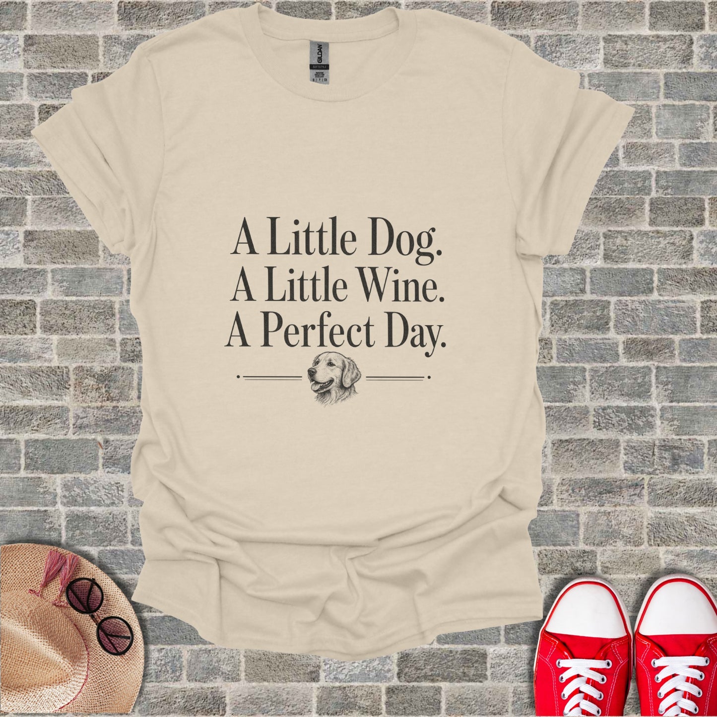 Cream t-shirt with text "A Little Dog. A Little Wine. A Perfect Day." and dog illustration.
