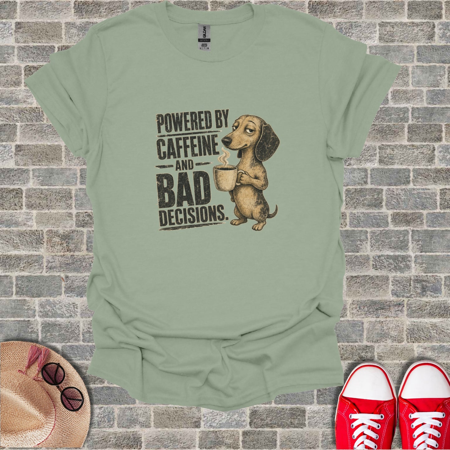 Dachshund with coffee cup on shirt that reads "Powered by Caffeine and Bad Decisions".