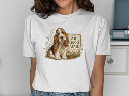 Basset hound wearing a bandana sits by a basket of flowers with "All Good AFaik" text.