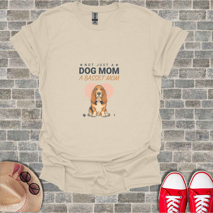 Cream t-shirt with graphic of basset hound and "Not Just A Dog Mom, A Basset Mom".