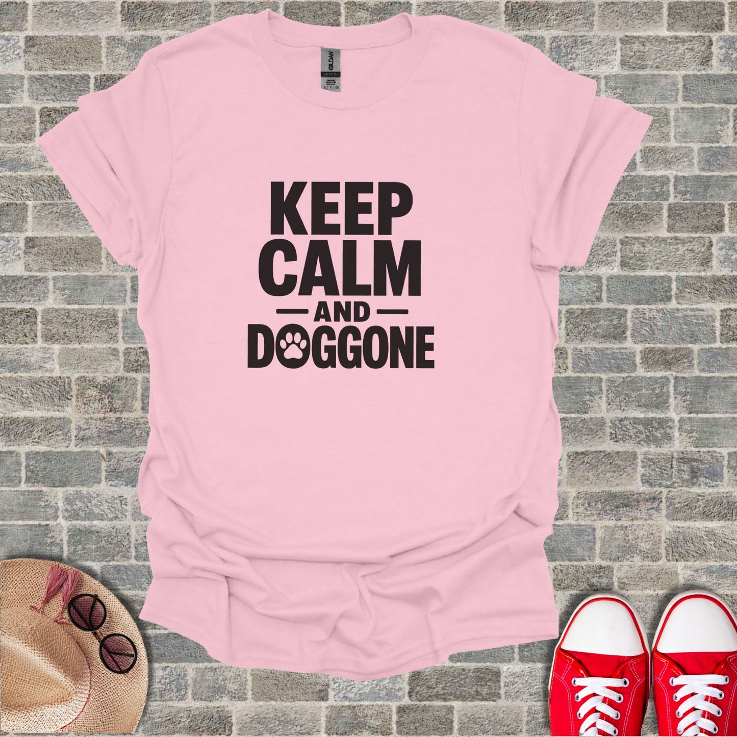 Pink t-shirt with text "KEEP CALM AND DOGGONE" and paw print graphic.