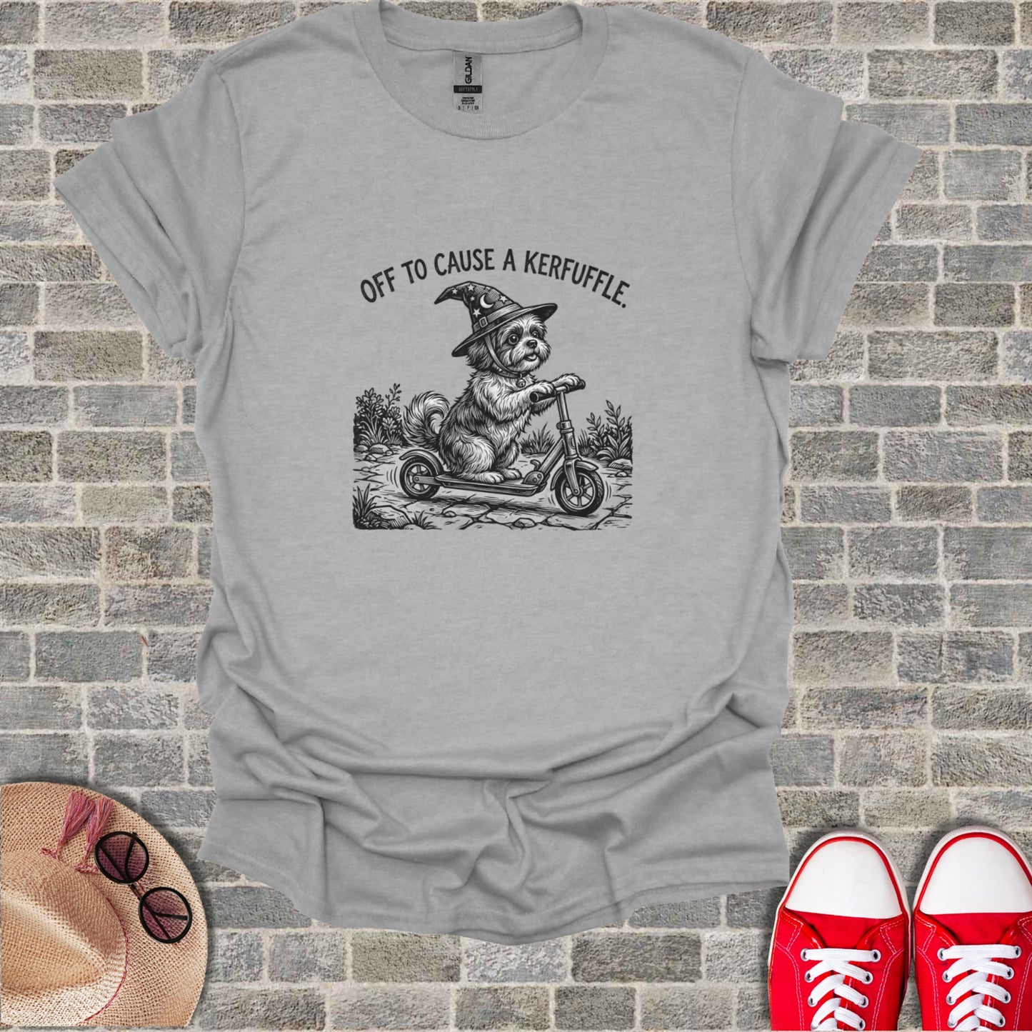 Dog in witch hat riding scooter with text "OFF TO CAUSE A KERFUFFLE".