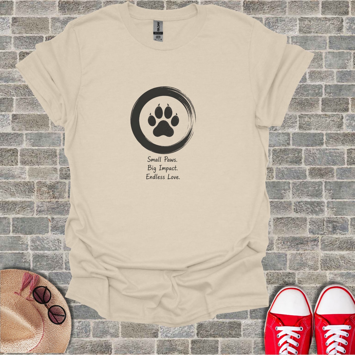 Cream t-shirt with a black paw print inside a circle and text.