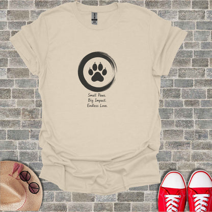 Cream t-shirt with a black paw print inside a circle and text.