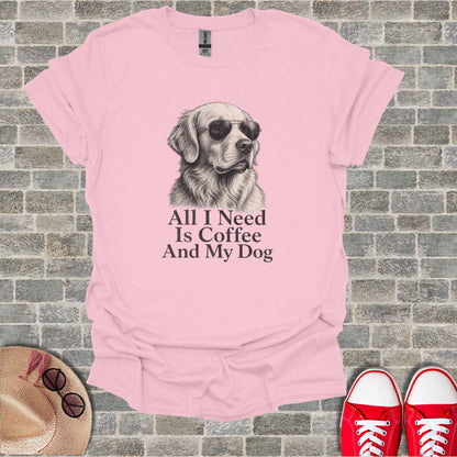 Pink t-shirt with sketch of golden retriever wearing sunglasses. Text reads "All I Need Is Coffee And My Dog".