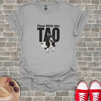 Basset hound wearing headphones, with text "Flow With The TAO" on a gray t-shirt.