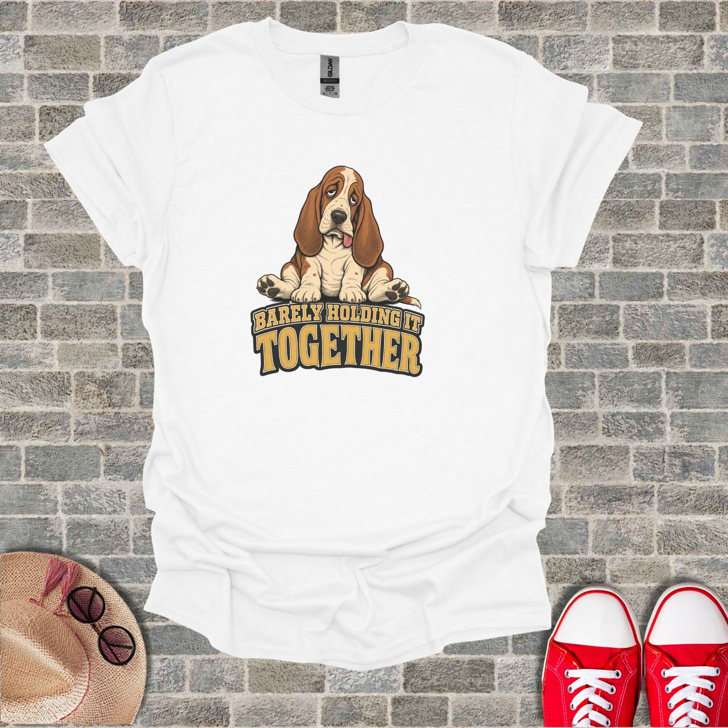 White t-shirt with cartoon basset hound and text "Barely Holding It Together".
