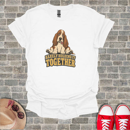 White t-shirt with cartoon basset hound and text "Barely Holding It Together".