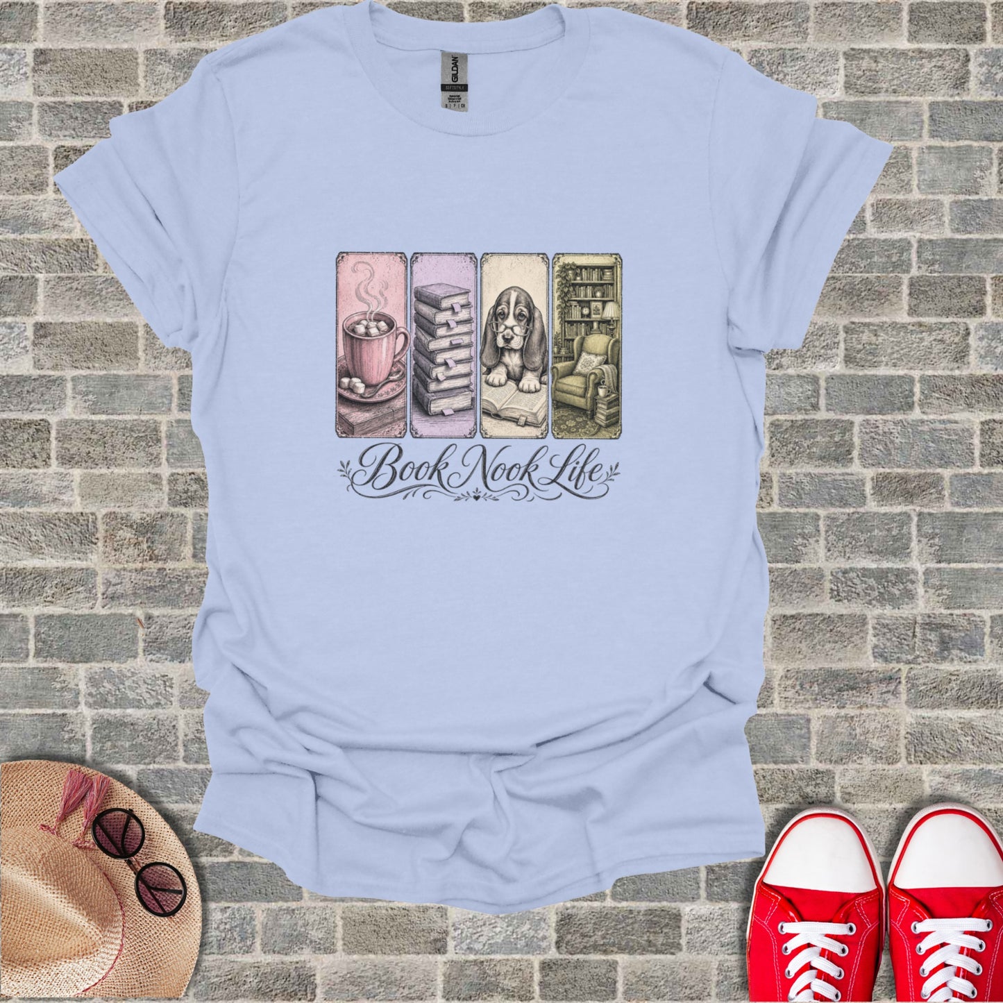 Light blue t-shirt with "Book Nook Life" and illustrations of books, a mug, and an armchair.