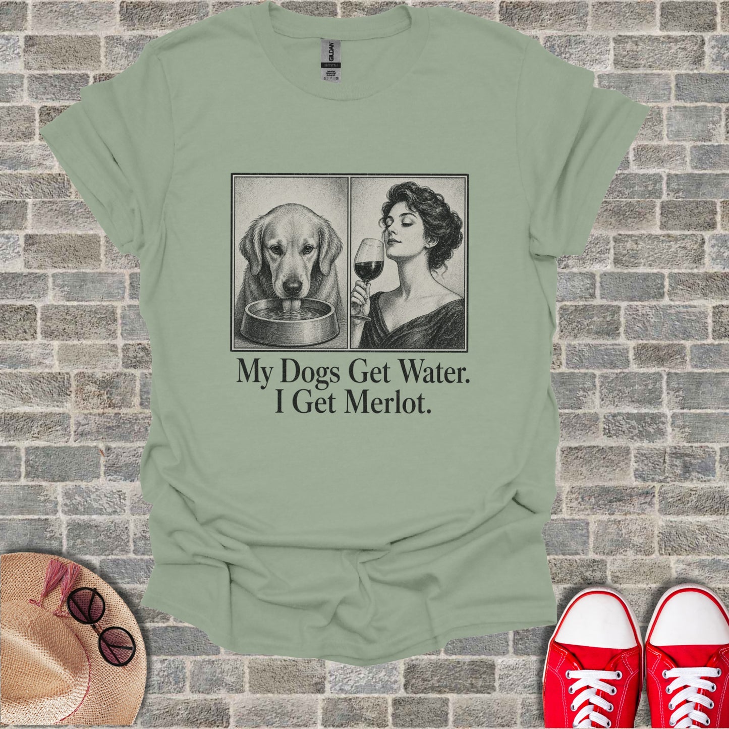 T-shirt with two illustrated panels: a dog drinking and a woman with wine. Text reads "My Dogs Get Water. I Get Merlot."