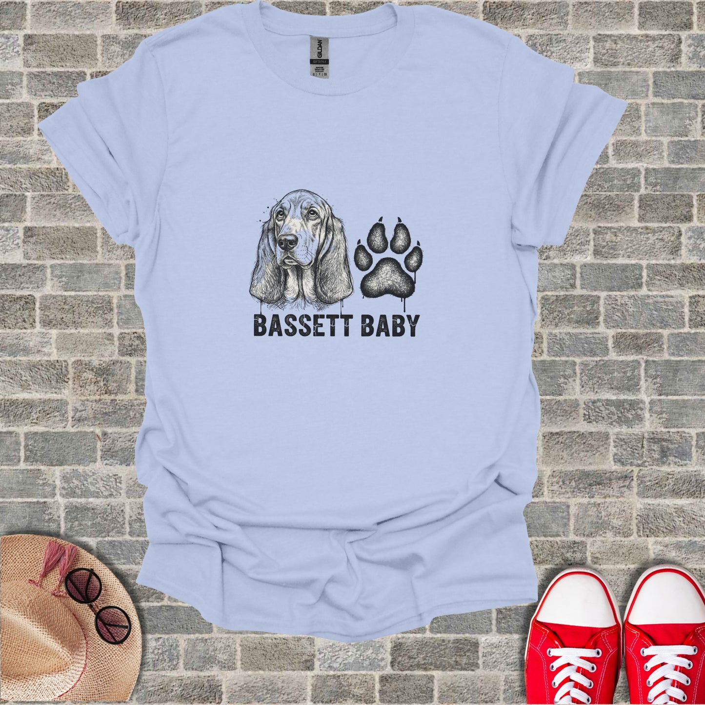 Light blue t-shirt with "BASSETT BABY" text and a sketched basset hound and paw print.