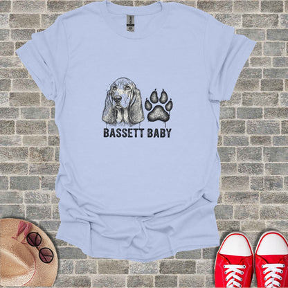 Light blue t-shirt with "BASSETT BABY" text and a sketched basset hound and paw print.