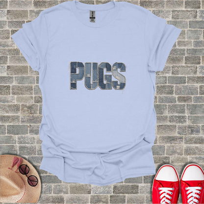Light blue t-shirt with "PUGS" in distressed denim font on a brick background.