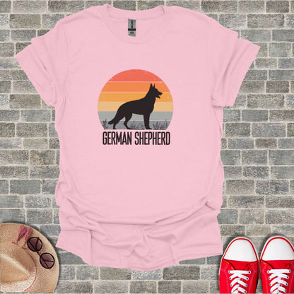 Pink t-shirt with a German Shepherd silhouette against a sunset graphic.