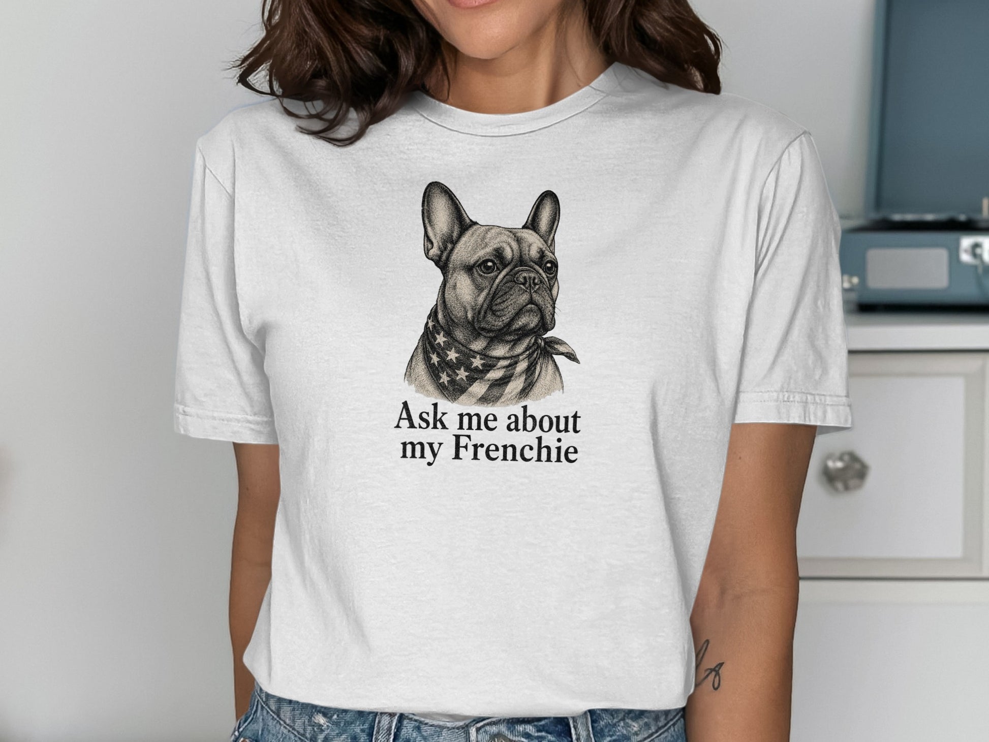 White t-shirt with a graphic of a French Bulldog wearing a star-spangled bandana and text.