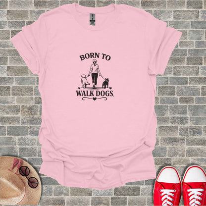 Pink t-shirt with "Born to Walk Dogs" graphic featuring a person and two dogs.