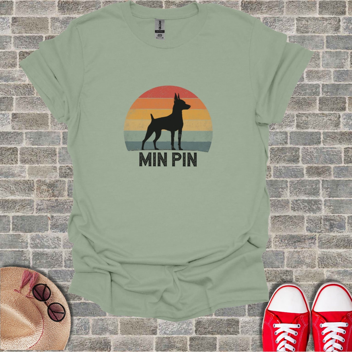 Silhouette of a Miniature Pinscher against a sunset, text reads "MIN PIN".