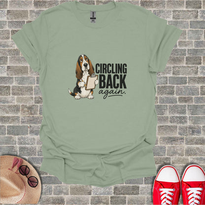 Basset Hound holding clipboard with text "CIRCLING back again."