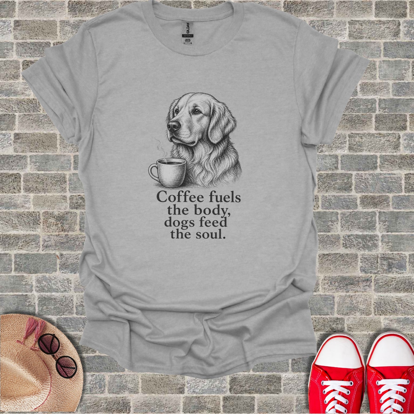 Grey t-shirt with a sketch of a golden retriever holding a coffee cup and the text "Coffee fuels the body, dogs feed the soul."