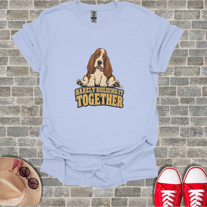 Light blue t-shirt with a sad basset hound and text "BARELY HOLDING IT TOGETHER".