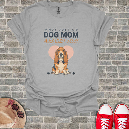 Grey t-shirt with "Not Just a Dog Mom a Basset Mom" and basset hound illustration.