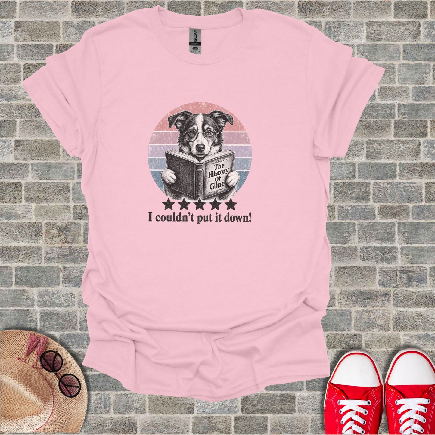 Pink t-shirt with a dog reading "The History of Glue" book.