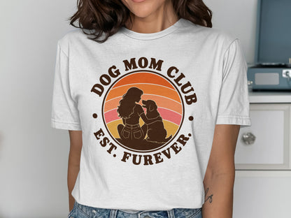 Dog Mom Club Est. Furever circular graphic with sunset and silhouettes of woman and dog.