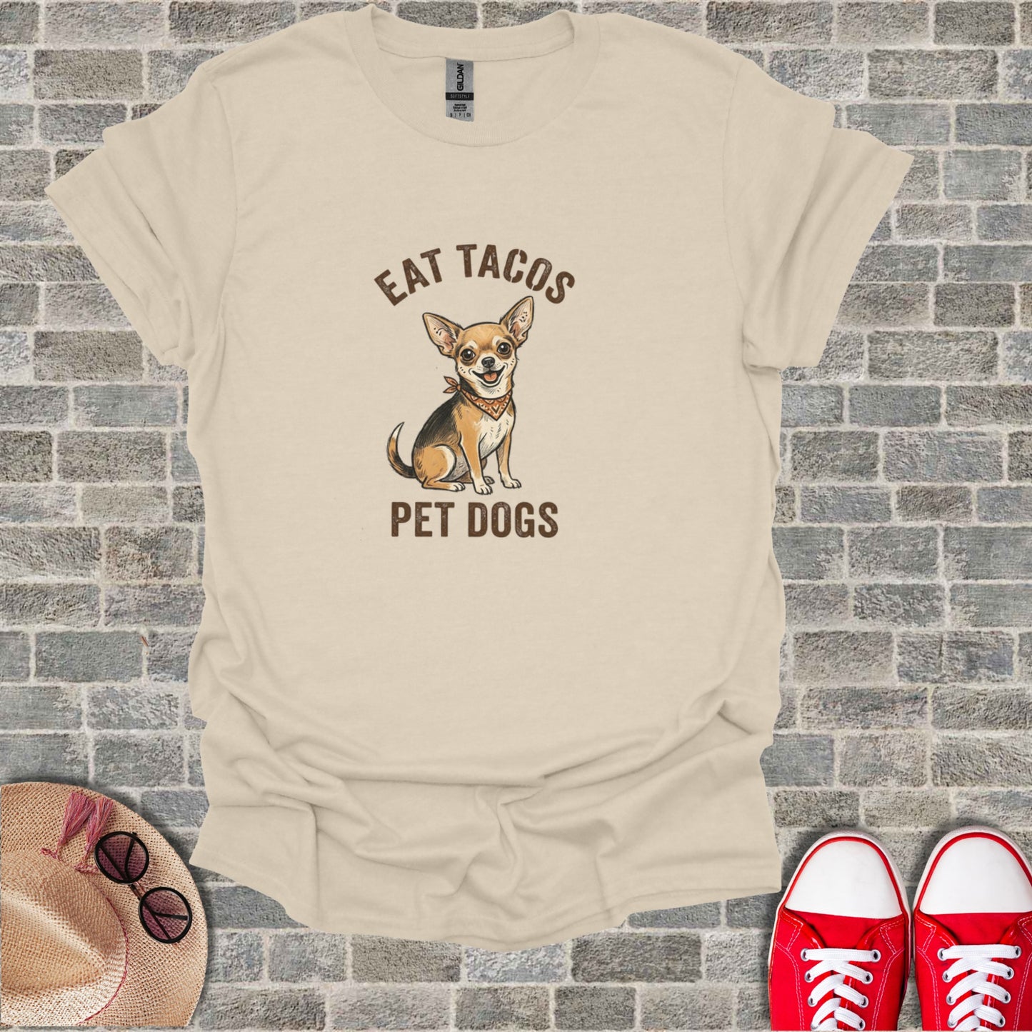 Cream t-shirt with cartoon chihuahua and text "EAT TACOS PET DOGS".