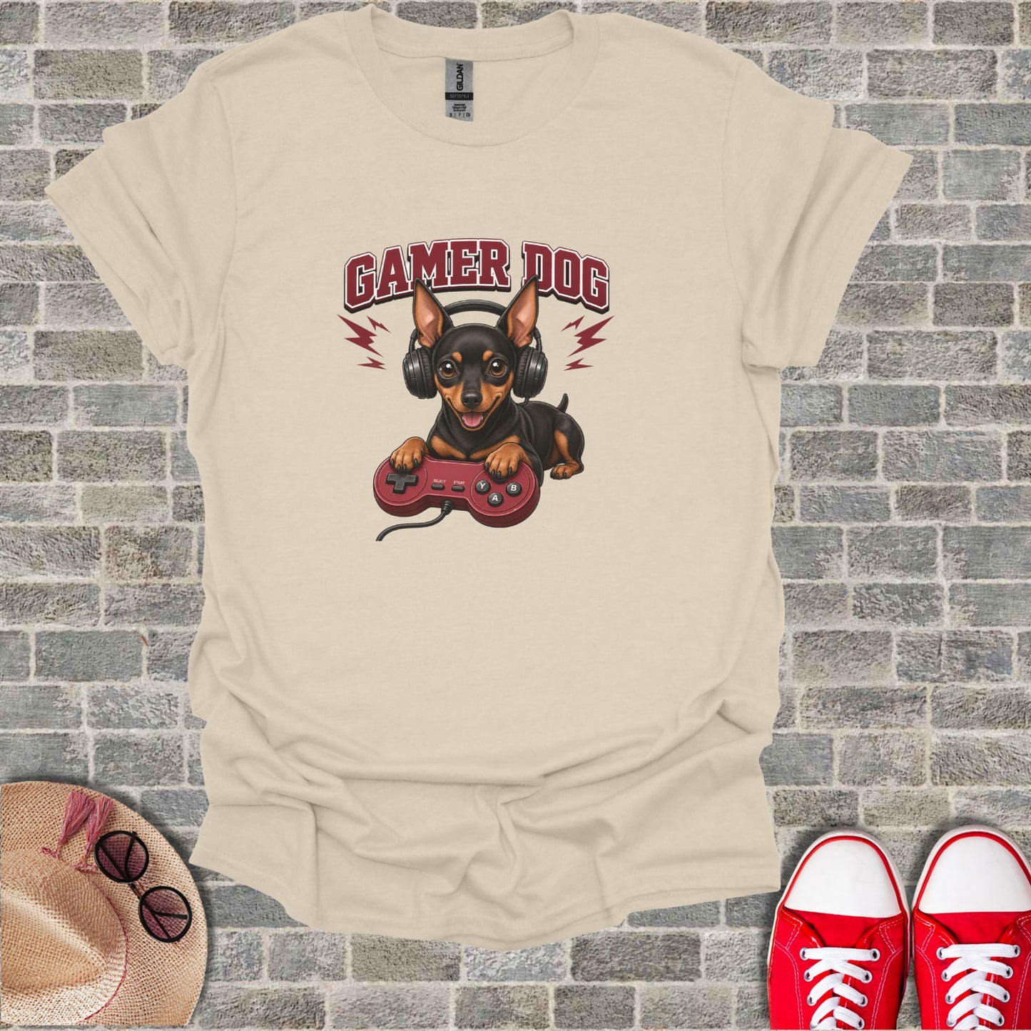 Tan t-shirt with a dog wearing headphones holding a video game controller.