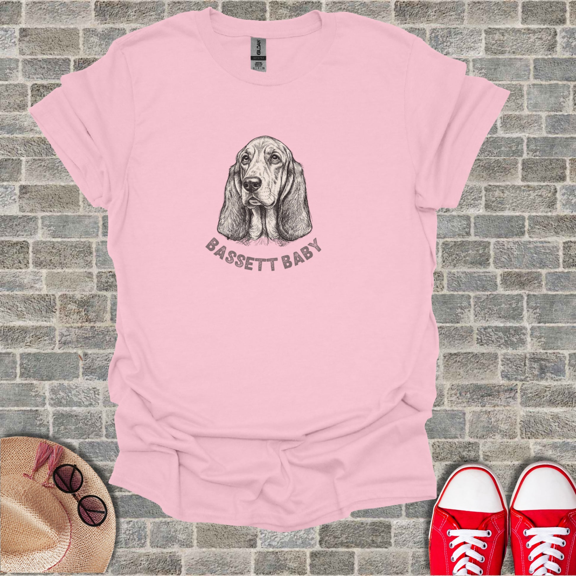 Pink t-shirt with a sketch of a basset hound and "BASSETT BABY" text.