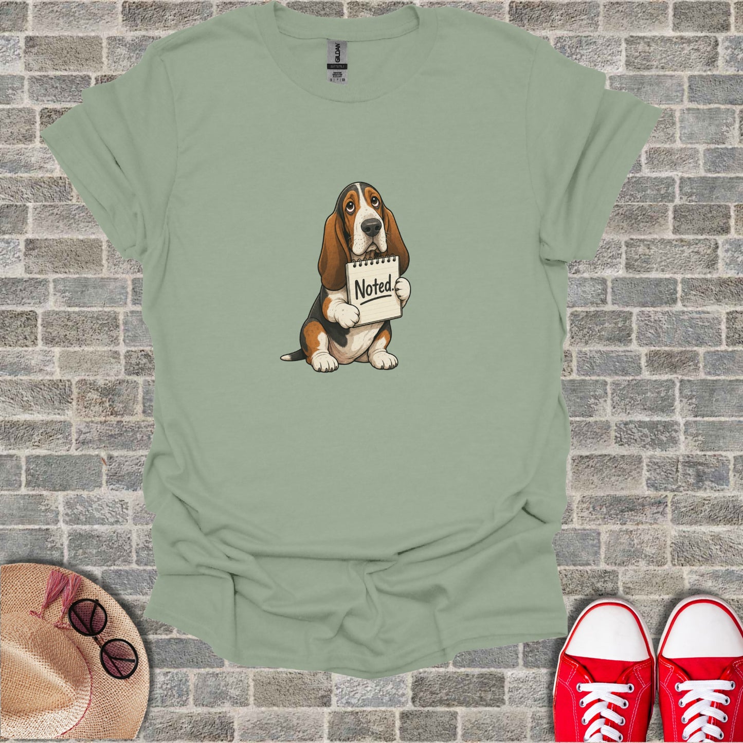 Basset hound holding a "Noted" sign with distressed expression.