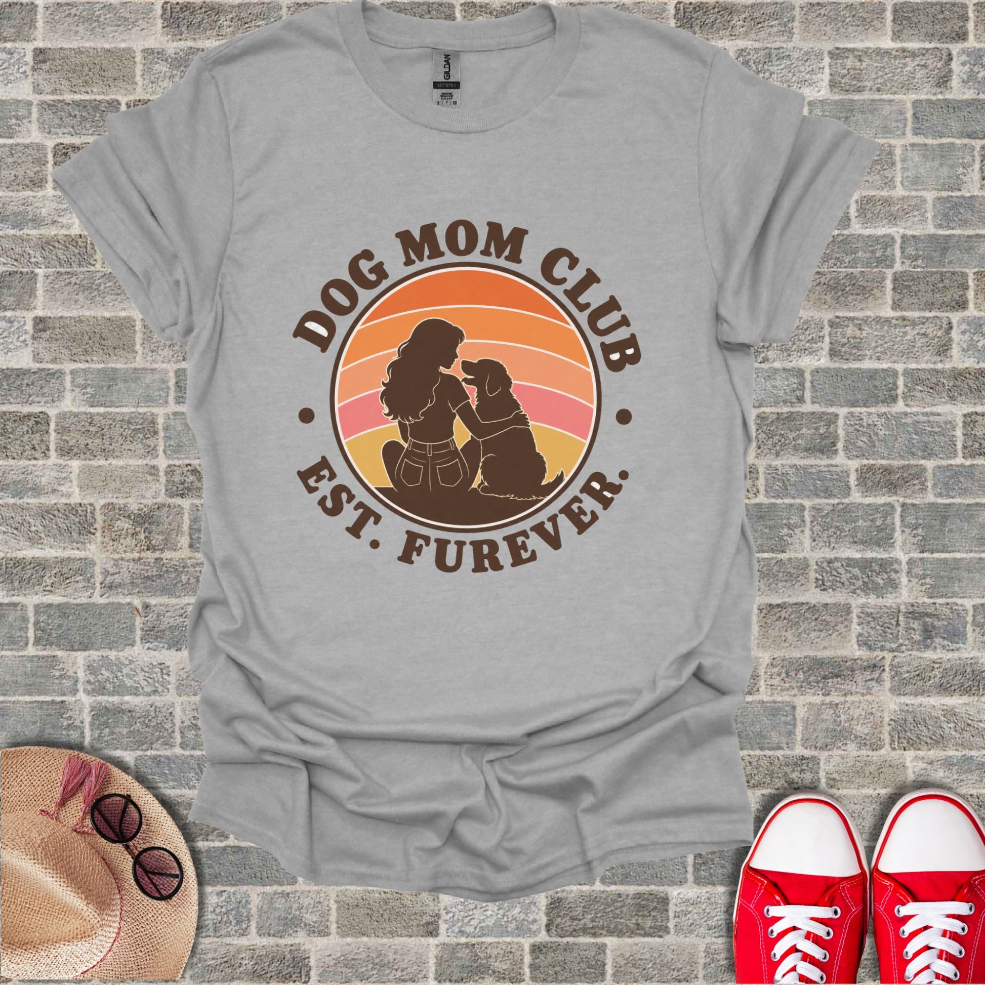 Gray t-shirt featuring a "Dog Mom Club Est. Furever" circle graphic with sunset and dog mom silhouette.