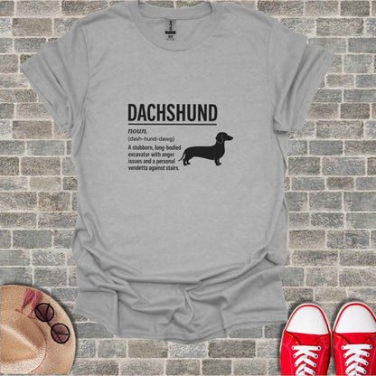 Gray t-shirt with "DACHSHUND noun. (dash-hund-dawg) A stubborn, long-bodied excavator with anger issues and a personal vendetta against stairs."