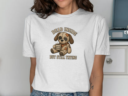 Illustration of a sad dog wearing a bandage, with text "DEAD INSIDE STILL TIRED".